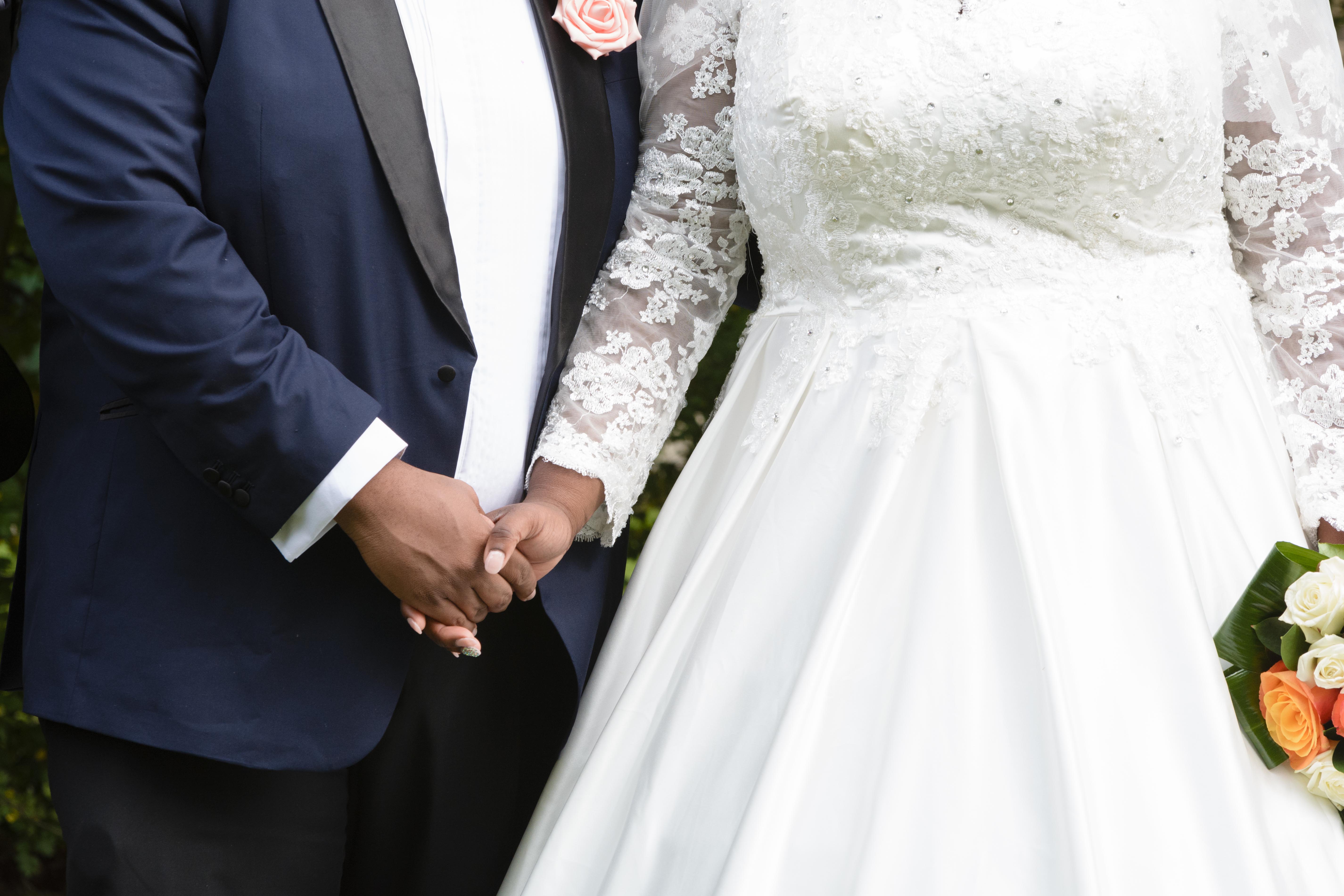 Picture of man and woman at wedding holding hands - church of england stock photo